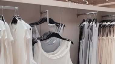 Moda, perakende ve alışveriş konsepti, giyim mağazasındaki askılarda çeşitli şık kıyafetler.