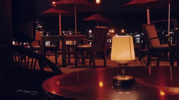 日付夜とインテリアデザインのコンセプト。海辺の屋外レストランのテーブルの上に小さなヴィンテージランプ — ストック動画