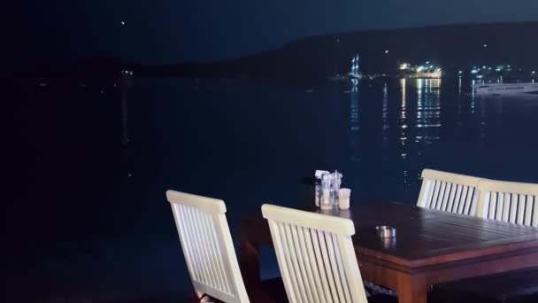 Seascape, jantar fino e conceito de férias, restaurante à beira-mar e reflexos de luzes na água da cidade costeira à noite — Vídeo de Stock