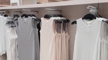 Moda, perakende ve alışveriş konsepti, giyim mağazasındaki askılarda çeşitli şık kıyafetler.