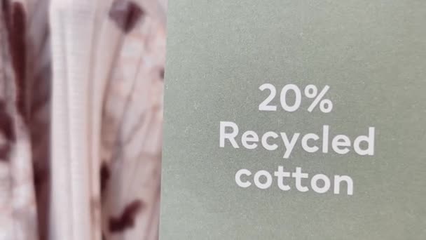 Concepto de moda y ropa sostenible. Etiqueta de algodón reciclado del 20 por ciento en la ropa en la tienda de la marca de ropa del mercado masivo en el centro comercial — Vídeo de stock