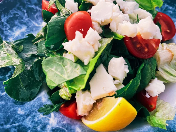 Dieta saludable, comida y concepto de cocina mediterránea. Ensalada con queso blanco y verduras verdes frescas en un restaurante al aire libre — Foto de Stock