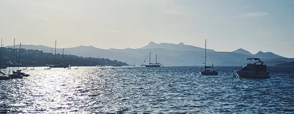 Tranquil θαλασσογραφία και παράκτια φύση έννοια. Θάλασσα, βάρκες, βουνά και γαλάζιος ουρανός πάνω από τον ορίζοντα στο ηλιοβασίλεμα — Φωτογραφία Αρχείου