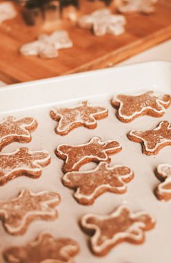 Noel pişirme ve yemek tarifi konsepti. Gıda malzemeleri ve geleneksel zencefilli kurabiye hazırlama süreci. Evdeki mutfakta erkekler bisküvileri.