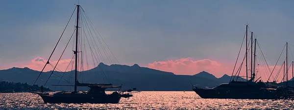 Концепція прибережної та морської природи. Море, човни, гори і блакитне небо над горизонтом на заході сонця — стокове фото