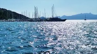 Gün batımında tekneler ve yatlarla yavaş çekim sahnesi. Deniz, yat ve seyahat konsepti.