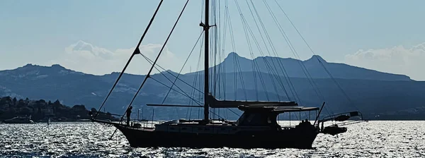 Sakin deniz manzarası ve kıyı doğası kavramı. Gün batımında deniz, kayıklar, dağlar ve mavi gökyüzü. — Stok fotoğraf