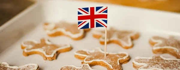 Vacaciones británicas y concepto de horneado de Navidad. Bandera Union Jack de Gran Bretaña y galletas de jengibre para hombres en la cocina de Inglaterra —  Fotos de Stock