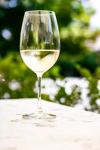 Weißwein im Luxusrestaurant auf Sommergartenterrasse, Weinverkostung im Weingut im Weinberg, Gourmettour und Urlaubsreise — Stockfoto