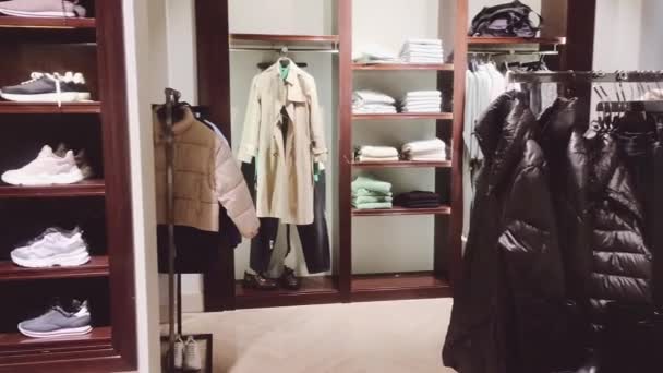 Ruházati kiskereskedelem és fenntartható divat koncepció. Luxus férfi ruházat választéka, őszi és téli kollekció a tömegpiaci márkaboltban — Stock videók