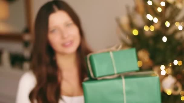 Vánoční svátky a ekologický současný koncept. Šťastná usměvavá žena držící dárkové krabice zabalené v udržitelném zeleném balicím papíru — Stock video