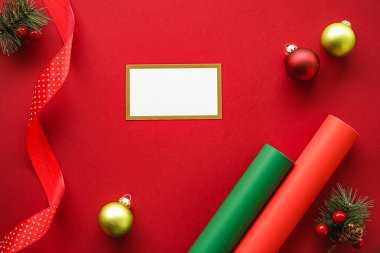 Bayram marka kimlik tasarımı ve Noel yassı yatak konsepti. Beyaz boş kartvizit ve xmas süsü ve kırmızı kağıt arka planda düz yatış modeli olarak dekorasyon