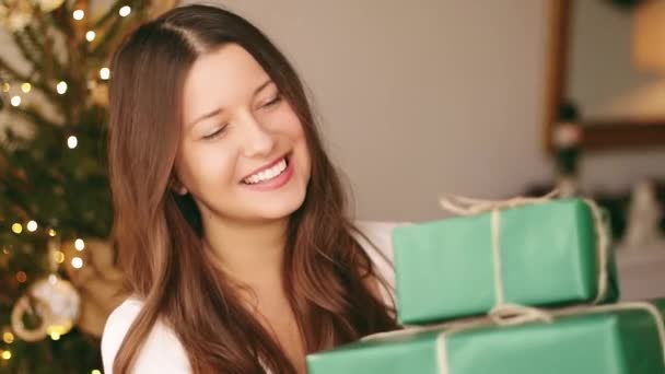 圣诞假期和环境友好型礼物的概念。快乐微笑的女人拿着礼品盒，用可持续的绿色包装纸包裹着 — 图库视频影像