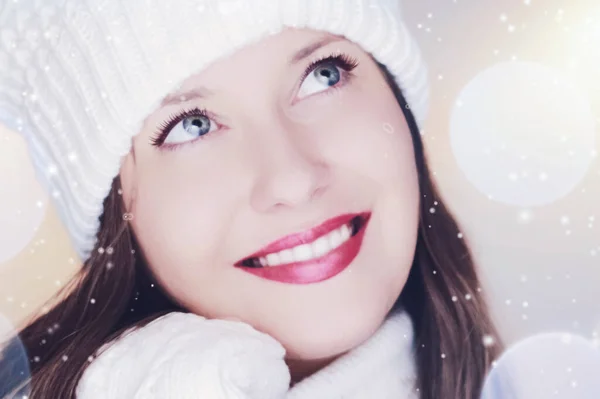 Christmas, people and winter holiday concept. Happy smiling woman wearing white knitted hat as closeup face xmas portrait, snow glitter and bokeh effect — Stock Photo, Image