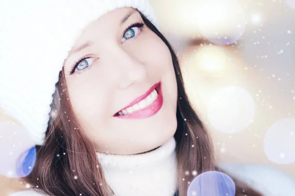 Christmas, people and winter holiday concept. Happy smiling woman wearing white knitted hat as closeup face xmas portrait, snow glitter and bokeh effect — Stock Photo, Image