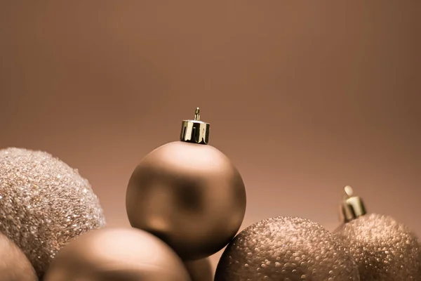 Natal férias e conceito de decoração festiva. Bugigangas douradas em fundo bege — Fotografia de Stock