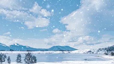 Kış harikalar diyarı ve kar yağan Noel manzarası. Karlı dağlarda donmuş göl ve tatil arkaplanı olarak karla kaplı ağaçlar.