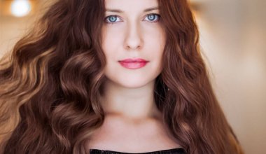 Saç modeli ve güzellik suratlı yakın plan. Uzun düz kahverengi saçlı, kıvırcık dalgalı, klasik cazibe tarzı ve lüks moda portresi olan güzel bir kadın.