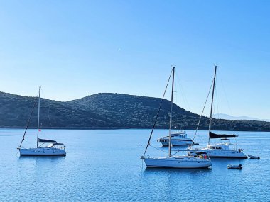 Riviera mavi deniz manzarası ve kıyı doğası kavramı. Sabahları deniz, yatlar ve dağlar