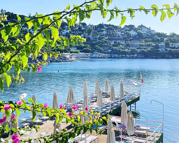 Riviera μπλε και καλοκαιρινές διακοπές έννοια. Παραλία με ξαπλώστρες και λευκές ομπρέλες στο πολυτελές παραθαλάσσιο θέρετρο δίπλα στη θάλασσα — Φωτογραφία Αρχείου