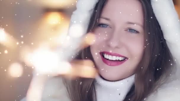 Zimowe wakacje i koncepcja świąt Bożego Narodzenia. Piękna uśmiechnięta kobieta w białym puszystym futrze trzymająca płonące ognie, śnieg i płatki śniegu — Wideo stockowe
