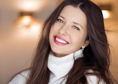 Kış portresi ve Noel tatili görüntüsü. Beyaz kazaklı, uzun kahverengi saçlı, çekici makyajlı, saç modeli ve xmas modası olan güzel bir kadın.