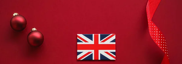 Brittisk jul tradition och semester design koncept. Union Jack flagga Storbritannien och xmas prydnader och dekoration på röd bakgrund som flatlay ovanifrån — Stockfoto