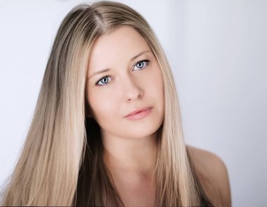 Güzellik modeli görünümü ve yüz resmi. Sarışın, uzun saçlı ve doğal makyajlı güzel bir kadın. Kozmetik ve sağlık ürünleri için klasik yakın plan.