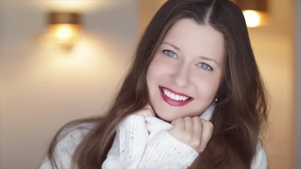 Beauté d'hiver et Noël look vacances. Belle femme souriante en pull tricoté blanc, maquillage rouge à lèvres et parfait sourire aux dents blanches — Video