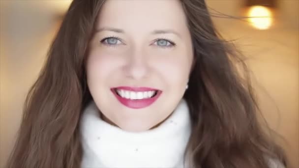 Zimní krása a vánoční svátky vzhled. Krásná usmívající se žena v bílém pleteném svetru, přírodní make-up a dlouhý účes s rozcuchanými vlasy — Stock video