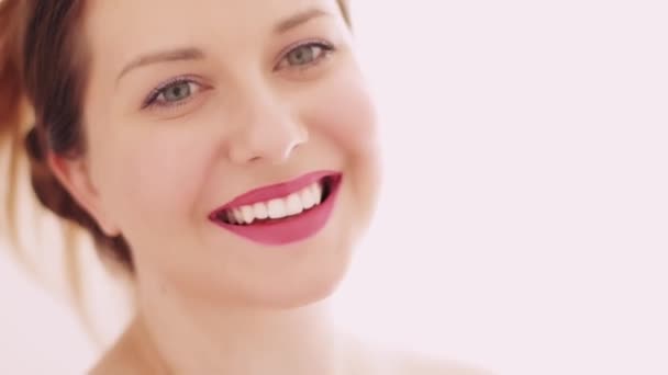 Портрет молодой женщины с улыбкой на лице, идеальная улыбка с белыми зубами, гламурный макияж с натуральной косметикой, красивая кавказская модель, позирующая для кожи и макияжа — стоковое видео