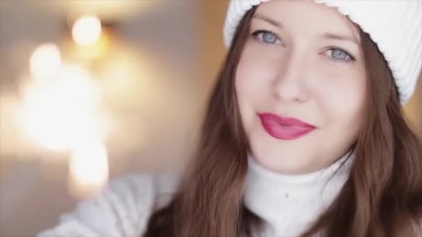 冬の休日やクリスマスのお祝いのコンセプト。幸せな笑顔女性で白い冬ニット帽とセーターを保持燃焼輝き — ストック動画