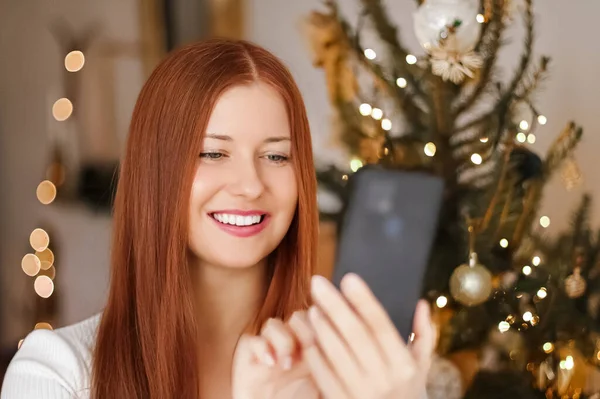 Christmas phone call and holiday greeting concept. Happy smiling woman using mobile smartphone on xmas day — Stock Photo, Image