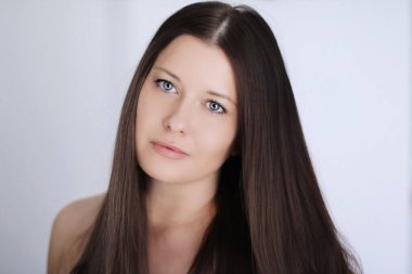 Güzellik modeli görünümü ve yüz resmi. Koyu renk saçlı, uzun saçlı ve doğal makyajlı güzel bir kadın. Kozmetik ve sağIık markası için klasik yakın plan.