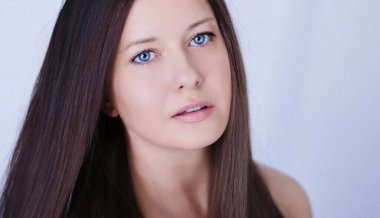 Güzellik, saç stili ve doğal makyaj. Uzun düz saçlı güzel bir kadın, kusursuz bir cilt ve organik kozmetik makyaj, yumuşak odaklı bir portre ve geçmişe dönük film tahıl etkisi