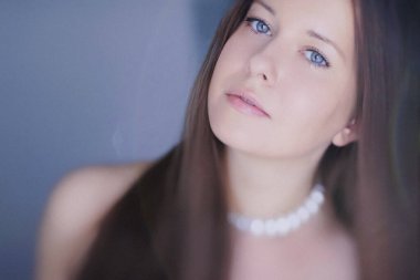 Güzellik, saç stili ve doğal makyaj. Uzun düz saçlı güzel bir kadın, kusursuz bir cilt ve organik kozmetik makyaj, yumuşak odaklı bir portre ve geçmişe dönük film tahıl etkisi