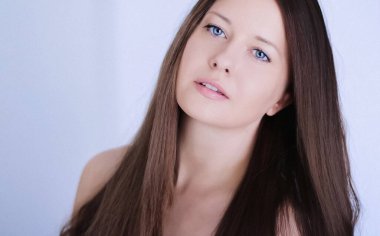 Güzellik, saç stili ve doğal makyaj. Uzun düz saçlı güzel bir kadın, kusursuz bir cilt ve organik kozmetik makyaj, yumuşak odaklı bir portre ve geçmişe dönük film tahıl etkisi