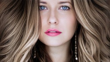 Saç modeli ve güzellik suratlı yakın plan. Uzun düz sarı saçlı güzel bir kadın kıvırcık dalgalar şeklinde, klasik cazibe stili ve lüks moda portresi.