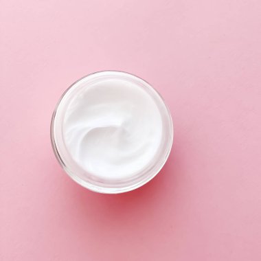 Pembe arka planda yüz kremi kavanozu, güzellik, cilt bakımı ve kozmetik ürünler.