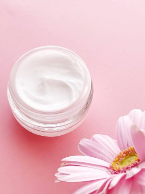 Yüz kremi kavanozu ve çiçek, güzellik, cilt bakımı ve kozmetik ürünler.