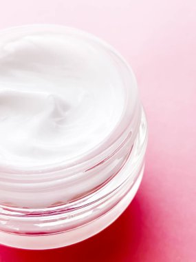 Pembe arka planda yüz kremi kavanozu, güzellik, cilt bakımı ve kozmetik ürünler.