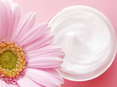 Yüz kremi kavanozu ve çiçek, güzellik, cilt bakımı ve kozmetik ürünler.