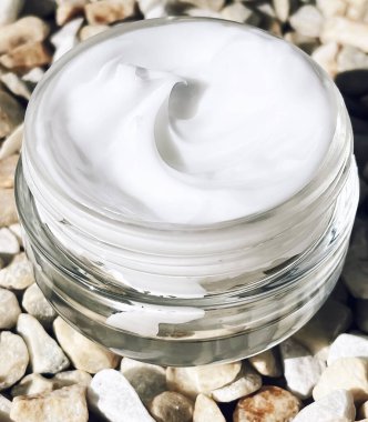 Yüz kremi nemlendirici, arka planda cam kavanoz, cilt bakımı ve kozmetik, güzellik ürünü konsepti.