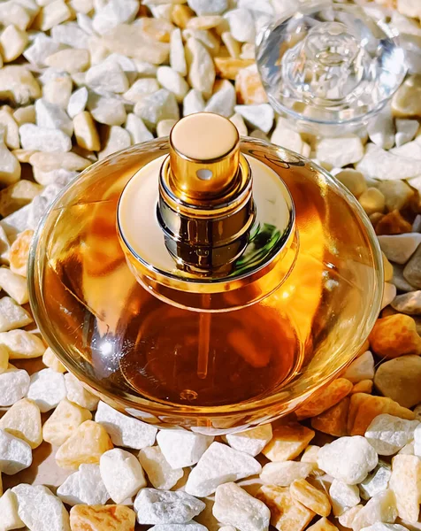 Parfüm şişesi, lüks koku, taş arka planda cam şişe, güzellik ürünü konsepti.