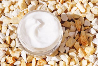 Yüz kremi nemlendirici, arka planda cam kavanoz, cilt bakımı ve kozmetik, güzellik ürünü konsepti.