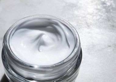 Yüz kremi nemlendirici, mermer taş arka planda cam kavanoz, cilt bakımı ve kozmetik, güzellik ürünü konsepti