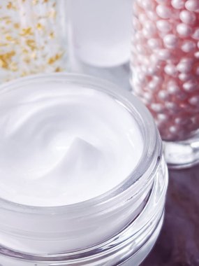 Cilt bakım ürünleri, yüz kremi nemlendirici kavanozu, altın serum emülsiyon şişeleri, yakın çekim güzellik ürünü.