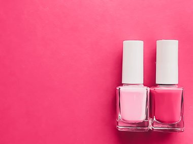 Gül arka planında pembe oje şişeleri, manikür ve güzellik kozmetik konsepti