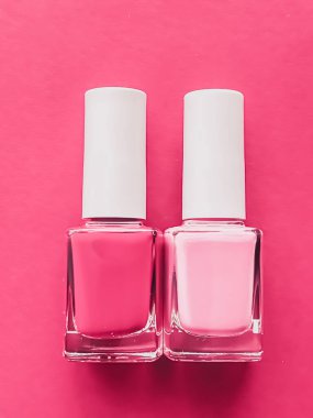 Gül arka planında pembe oje şişeleri, manikür ve güzellik kozmetik konsepti