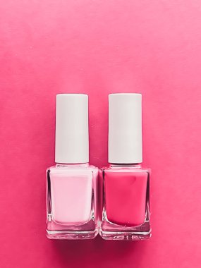 Gül arka planında pembe oje şişeleri, manikür ve güzellik kozmetik konsepti